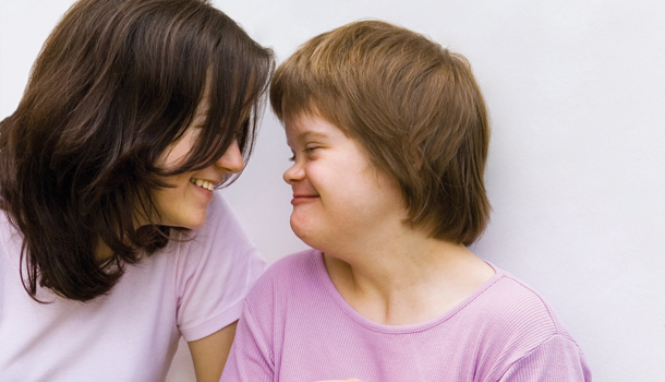 Das Bild zeigt eine ehrenamtliche Betreuerin und ein Mädchen mit Behinderung.